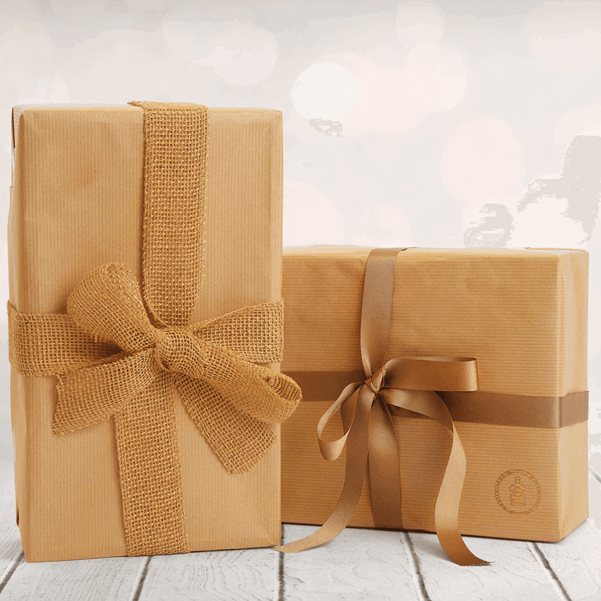 Two Fathers Day Gift Hampers wrapped in brown paper, and each tied with a bown ribbon.