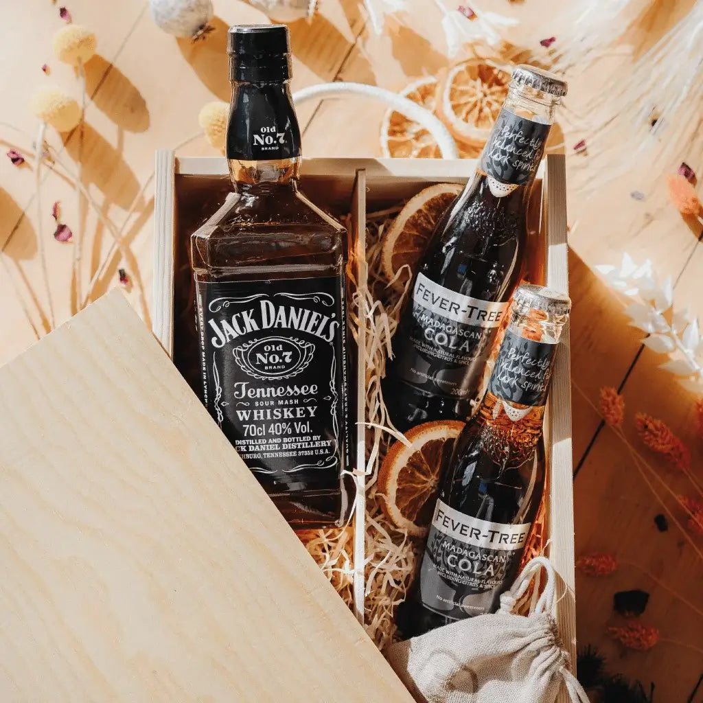 Close up of a Jack Daniels Fathers Day Gift Box containing a bottle of Jack Daniels, and 2 Fever Tree bottles of Cola, decorated with two dried oranges.
